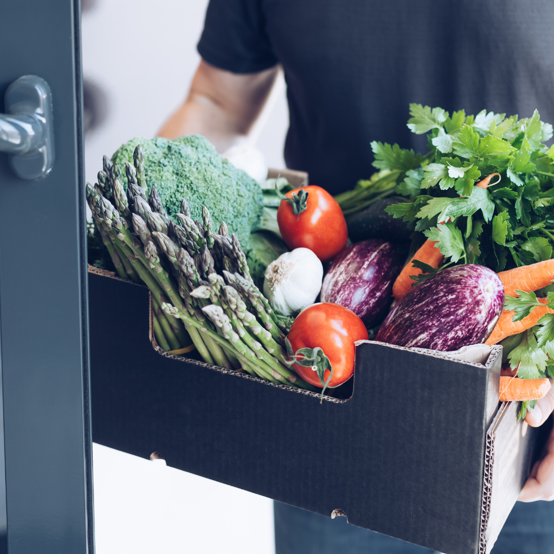 A happy customer receiving a grocery delivery, highlighting flexible shopping options like delivery or in-store pickup.